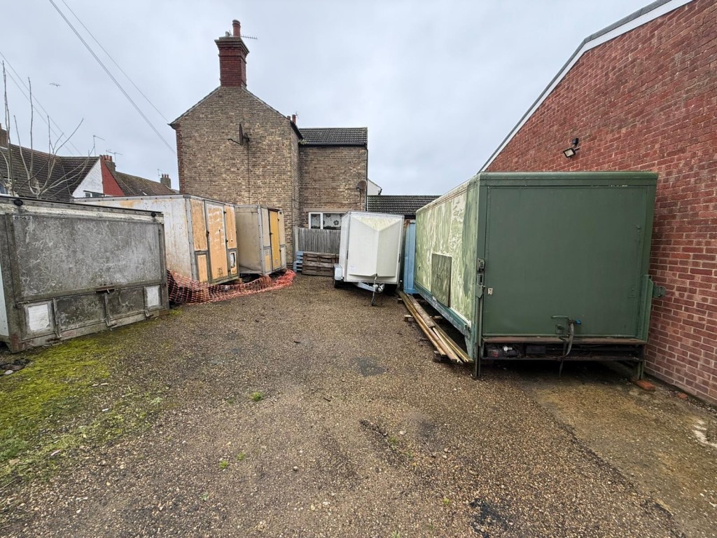 Lot: 77 - TWO PLOTS OF FREEHOLD LAND - Left side of land showing containers